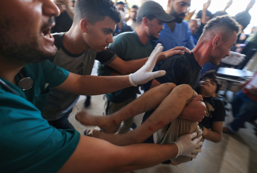 فلسطينيون ينقلون طفلاً مصاباً إلى مستشفى "ناصر" في أعقاب الغارات الإسرائيلية على خان يونس في جنوب قطاع غزة في 30 تشرين الأول/أكتوبر 2023 (أ ف ب)