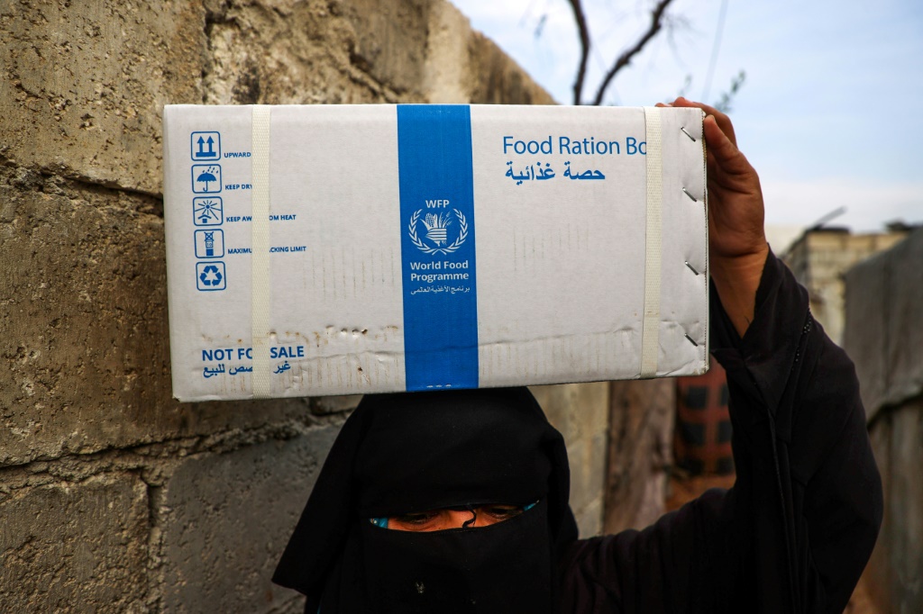 نازحة سورية تحمل صندوق مساعدات من برنامج الأغذية العالمي في أطمة بتاريخ 6 كانون الأول/ديسمبر 2023 (ا ف ب)