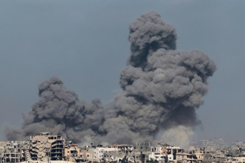 مروحية عسكرية إسرائيلية تطلق النار من مدفع رشاش خلال غارة إسرائيلية على غزة (أ ف ب)   