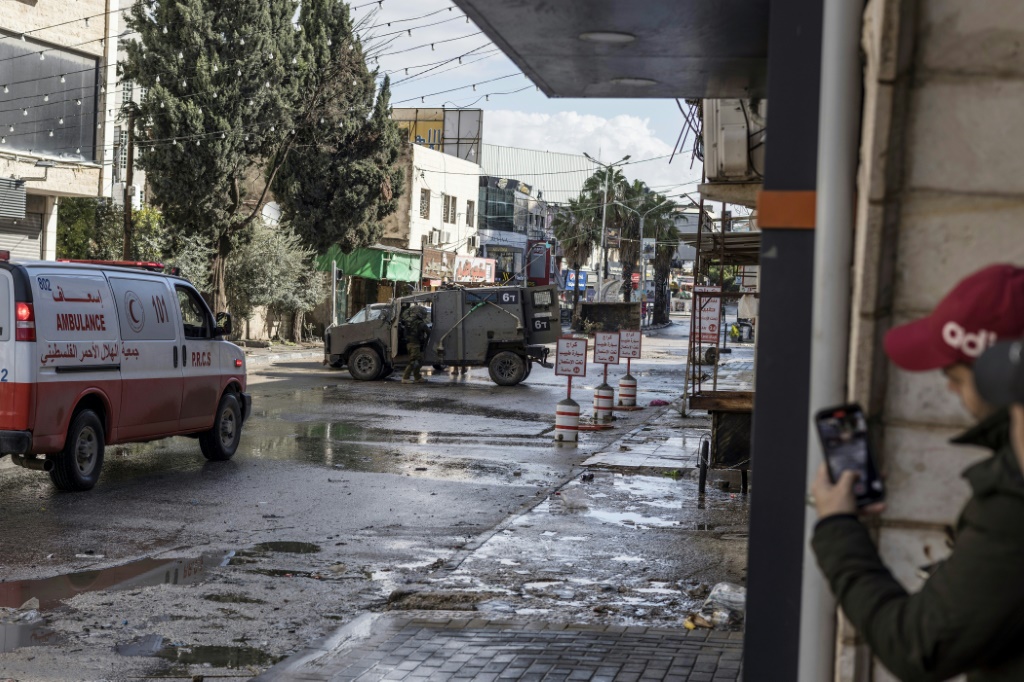 أغلقت سيارة دورية تابعة للجيش الإسرائيلي أحد طرق الدخول إلى مخيم جنين للاجئين في الضفة الغربية المحتلة، في الوقت الذي تواصل فيه القوات غارة أسفرت عن مقتل 11 فلسطينيا منذ يوم الثلاثاء. (أ ف ب)   
