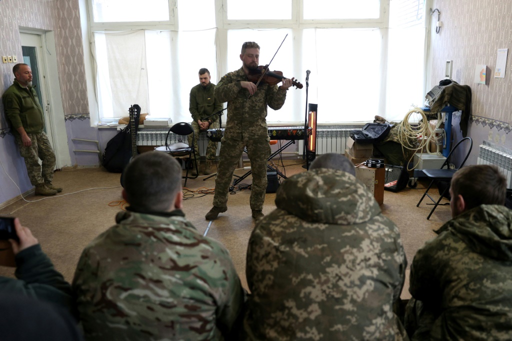 أحد موسيقيي القوات الثقافية الأوكرانية يؤدي عرضًا للجنود المتعافين في مركز في منطقة دونيتسك الشرقية ( ا ف ب)