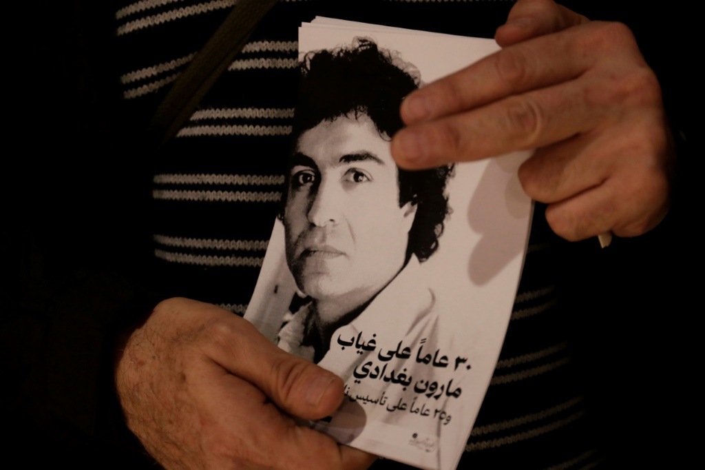 رجل يحمل صورة للمخرج اللبناني الفرنسي الراحل مارون بغدادي في موقع مخصص لأنشطة تقام في بيروت لمناسبة ذكرى مرور ثلاثين عاماً على وفاته، في 12 كانون الأول/ديسمبر 2023 (ا ف ب)