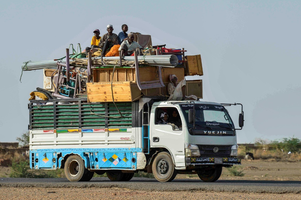 شاحنة صغيرة تنقل أشخاصا وحاجيات على الطريق بين العاصمة السودانية الخرطوم ومدينة ود مدني في صورة مؤرخة 22 حزيران/يونيو 2023(أ ف ب)   
