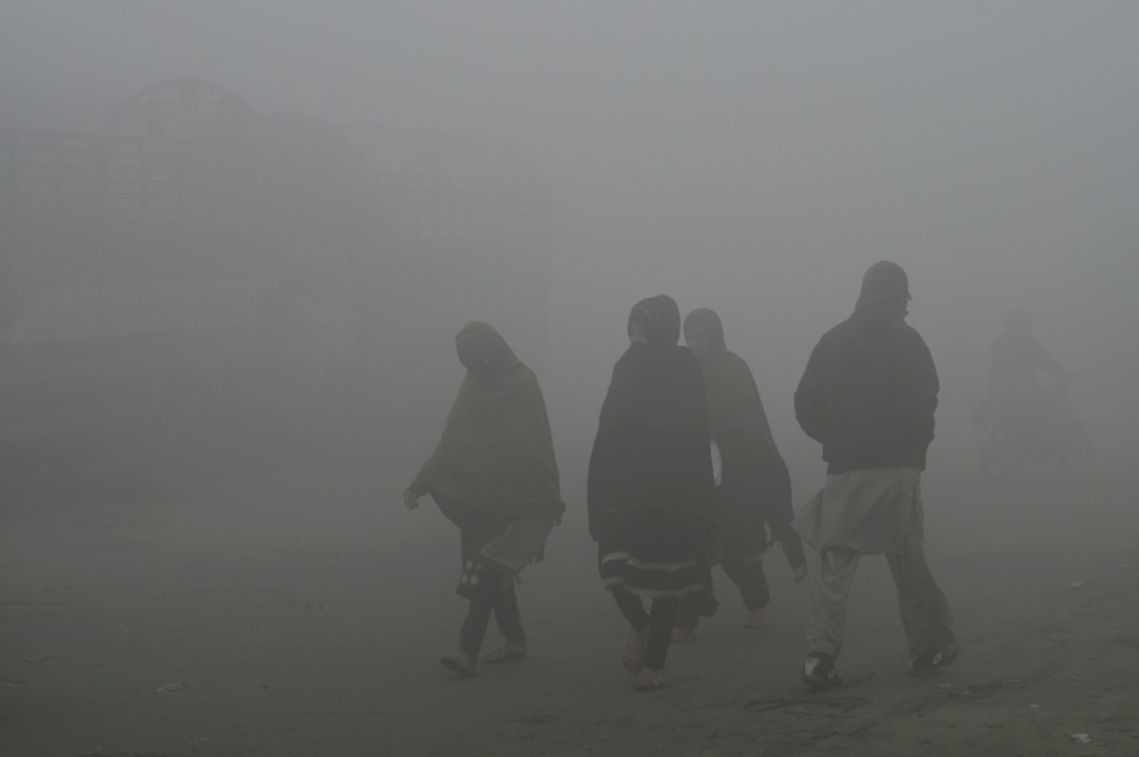 صورة مؤرخة في 14 كانون الأول/ديسبمر 2023 لأشخاص في لاهور التي يخنقها الضباب الدخاني (ا ف ب)