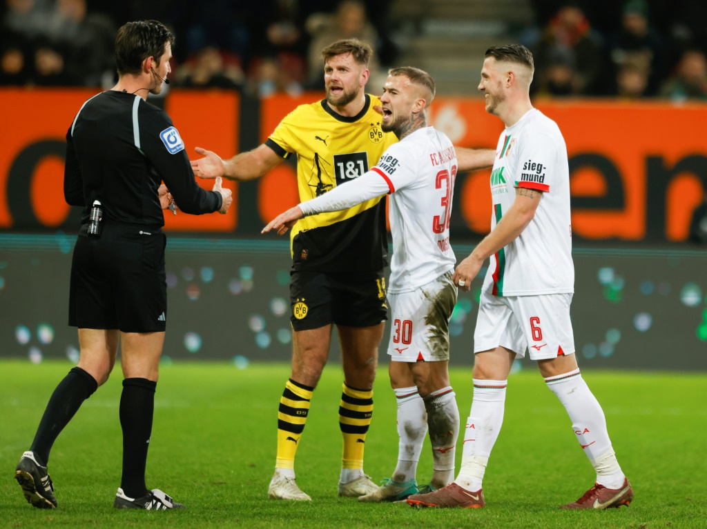 مهاجم بوروسيا دورتموند نيكلاس فولكروغ في حديث مع حكم المباراة خلال تعادل فريقه أمام مضيفه أوغسبورغ 1-1 في 16 كانون الأول/ديسمبر 2023 (ا ف ب)