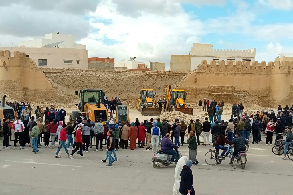 حشد من المتفرجين يتجمعون بالقرب من الجزء المنهار من الجدار حول مدينة القيروان القديمة، وهي أحد مواقع التراث العالمي لليونسكو وواحدة من مناطق الجذب السياحي الرائدة في تونس (ا ف ب)