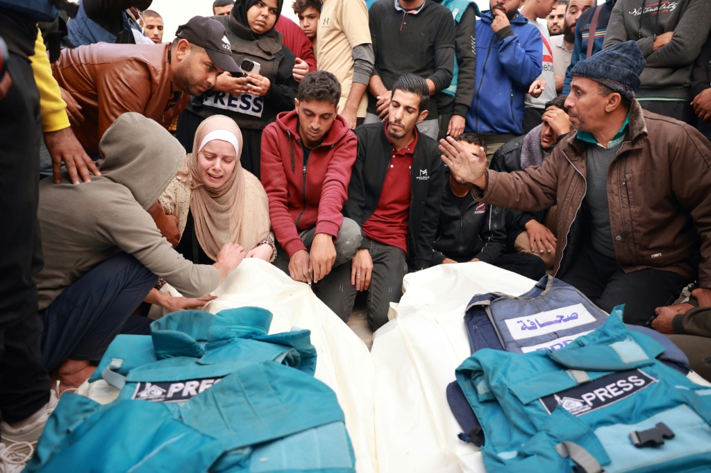 أقارب وزملاء الصحافيين الفلسطينيين حسونة سليم وساري منصور اللذين قُتلا في غارة إسرائيلية يبكون على جثتيهما خلال جنازتهما في دير البلح بجنوب قطاع غزة في 19 تشرين الثاني/نوفمبر 2023 (ا ف ب)