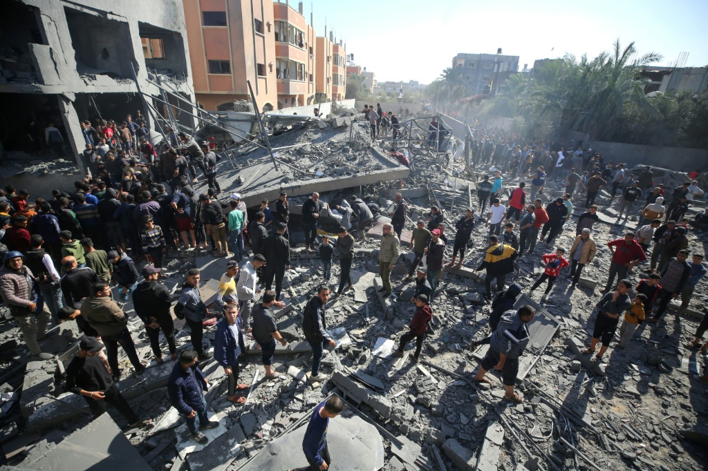 فلسطينيون يبحثون عن ناجين في أنقاض مبنى دمر في ضربة إسرائيلية في مخيم المغازي في وسط قطاع غزة في 11 كانون الأول ديسمبر 2023 (ا ف ب)