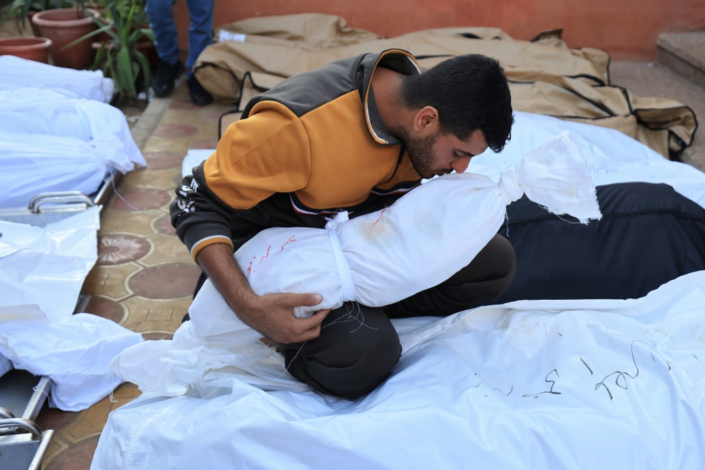 فلسطيني يقبّل جثمان أحد أفراد عائلته الذي قتل في غارة اسرائيلية على خان يونس بجنوب قطاع غزة، في 18 تشرين الثاني/نوفمبر 2023 (ا ف ب)