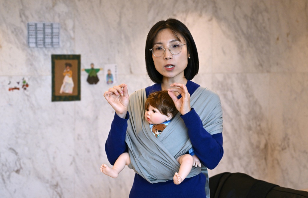 إيرين ليم، الرئيس التنفيذي لشركة كوني التي أسستها والمتخصصة في حمالات الأطفال، تعرض أحد نماذجها الأولية في منزلها في سيول، 29 نوفمبر 2023 (ا ف ب)
