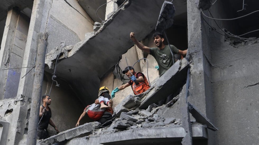 فلسطينيون في مبنى مدمر بقصف إسرائيلي في خان يونس جنوب قطاع غزة، 19 تشرين الأول- أكتوبر 2023.(أ ف ب)