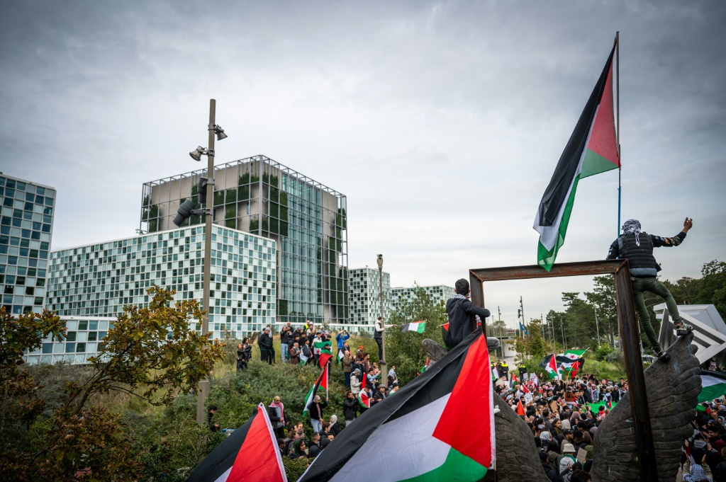 تجمع مئات الأشخاص وهم يحملون العلم الفلسطيني واللافتات أمام مدرسة باركلي الابتدائية في لوتون صباح يوم الخميس (أ ف ب)