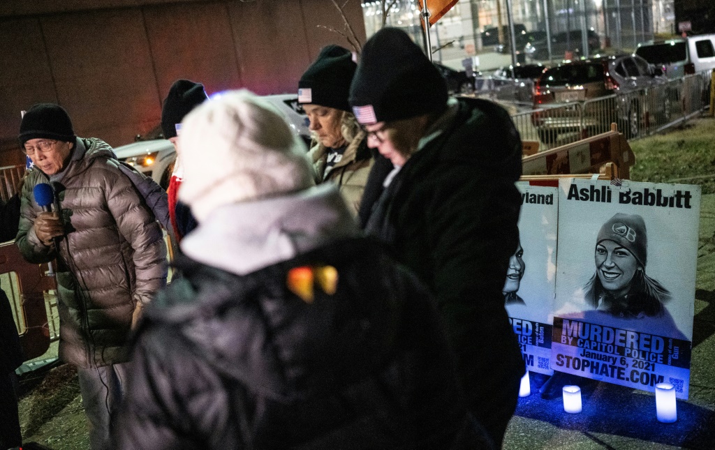 دوايت ين (يسار) يقود صلاة الوقفة الاحتجاجية للمتهمين بأحداث 6 يناير خارج السجن في واشنطن (أ ف ب)   
