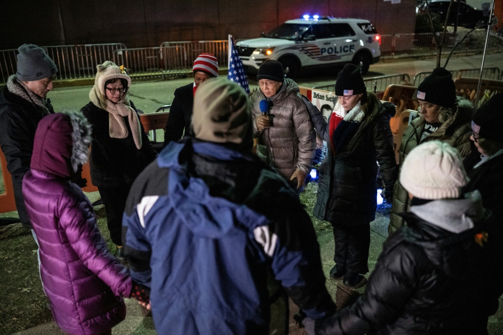 أشخاص يصلّون لمحتجزين على خلفية الهجوم على الكابيتول أمام سجنهم في واشنطن في الثالث من كانون الثاني/يناير 2024 (ا ف ب)