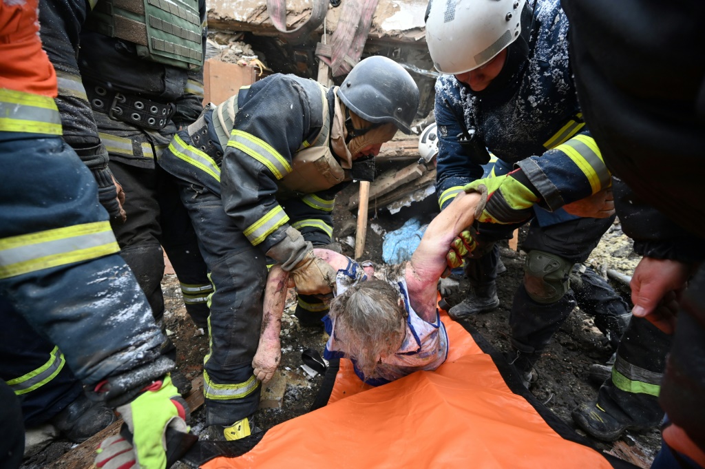    عناصر إغاثة وشرطة يحملون جثة ضحية بعد ضربات روسية على زمييف في منطقة خاركيف الأوكرانية في الثامن من كانون الثاني/يناير 2024 (أ ف ب)   