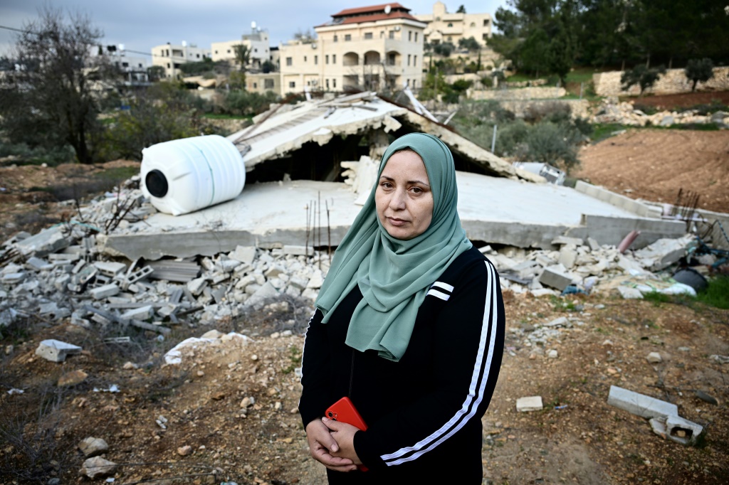 القروية الفلسطينية غدير الأطرش أمام منزلها الذي دمرته الجرافات في الولجة (أ ف ب)   