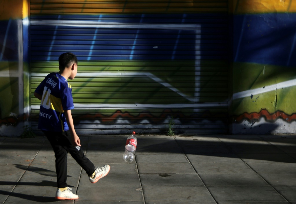 صورة مؤرخة في 4 تشرين الثاني/نوفمبر 2023 لصبي يلعب بزجاجاة مياه بلاستيك في بوينوس ايرس (أ ف ب)   