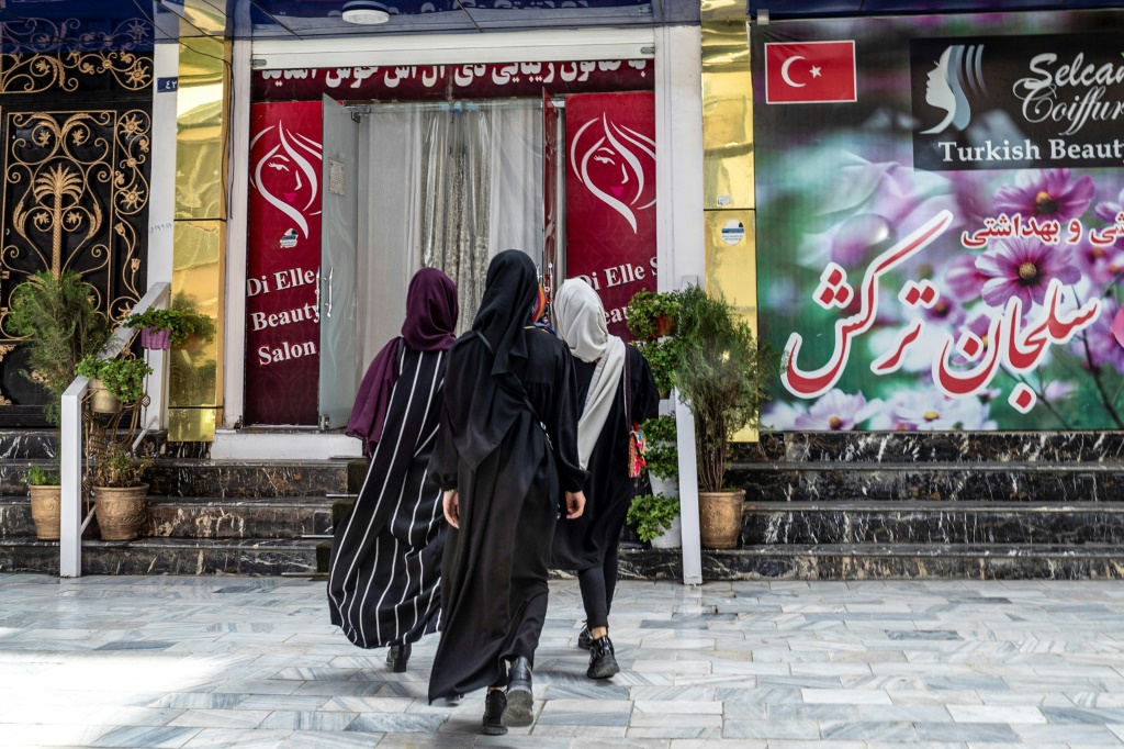 نساء يدخلن إلى صالون تجميل في منطقة شهر نو في كابول في يوليو 2023 (أ ف ب)   