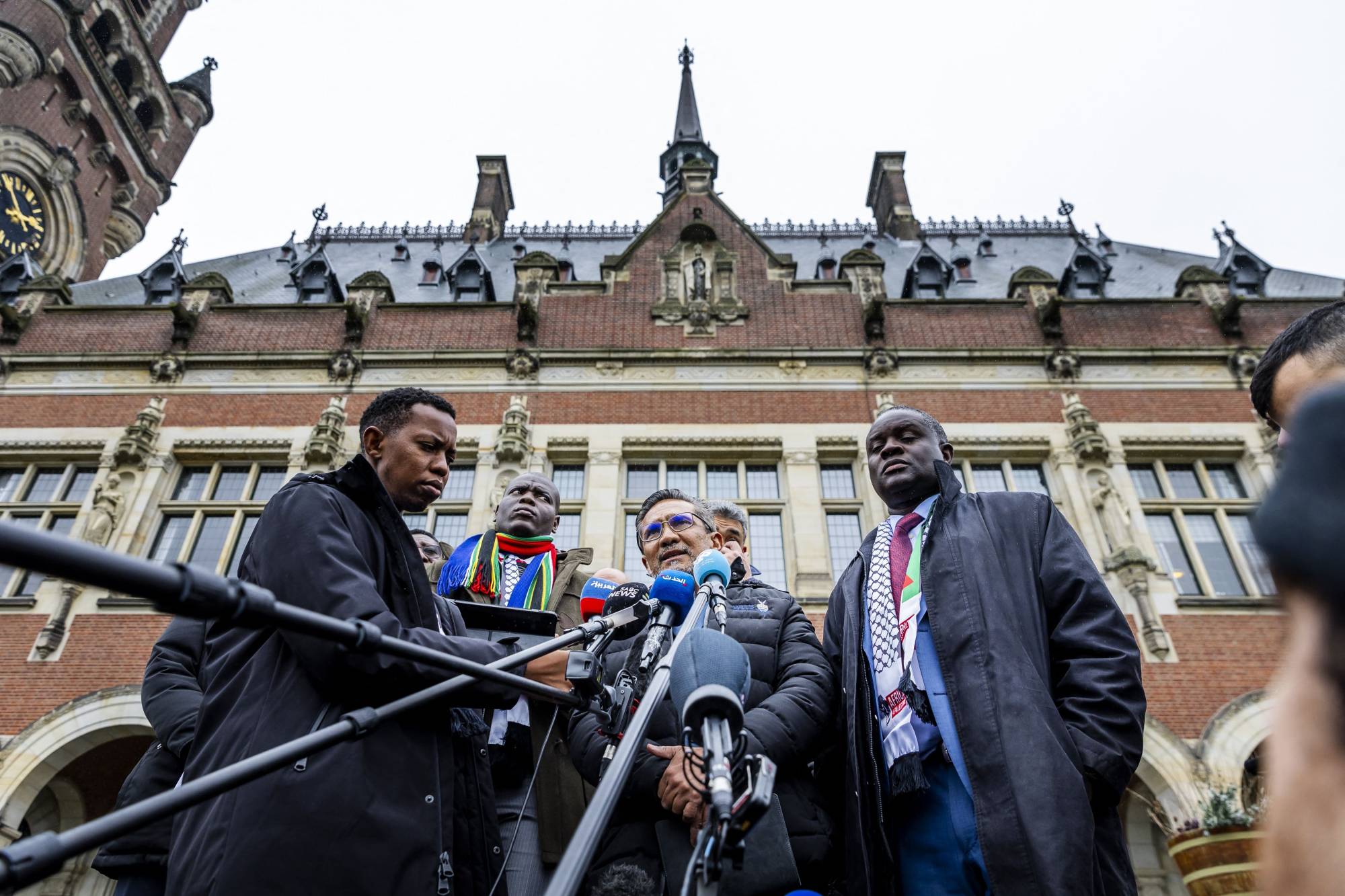 أعضاء وفد جنوب أفريقيا يتحدثون للإعلام أمام محكمة العدل الدولية في لاهاي الجمعة (أ.ف.ب)
