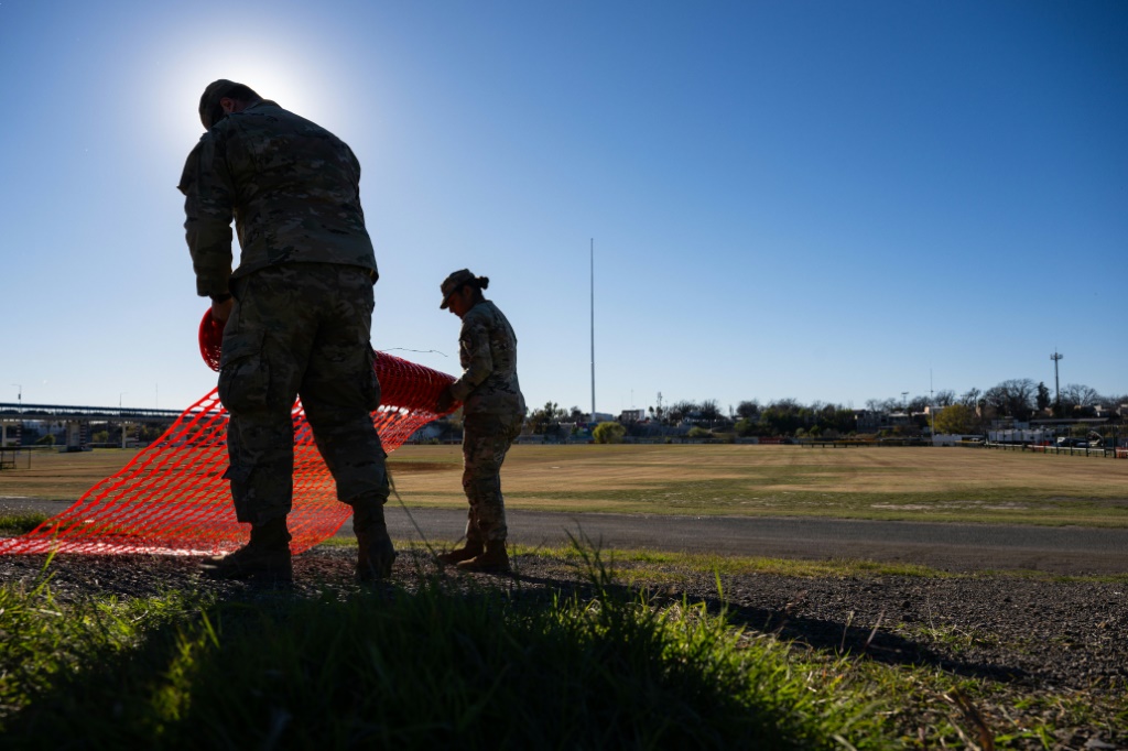 جنود الحرس الوطني يشمرون السياج على ضفاف نهر ريو غراندي في شيلبي بارك في 12 يناير 2024 في إيجل باس، تكساس (أ ف ب)