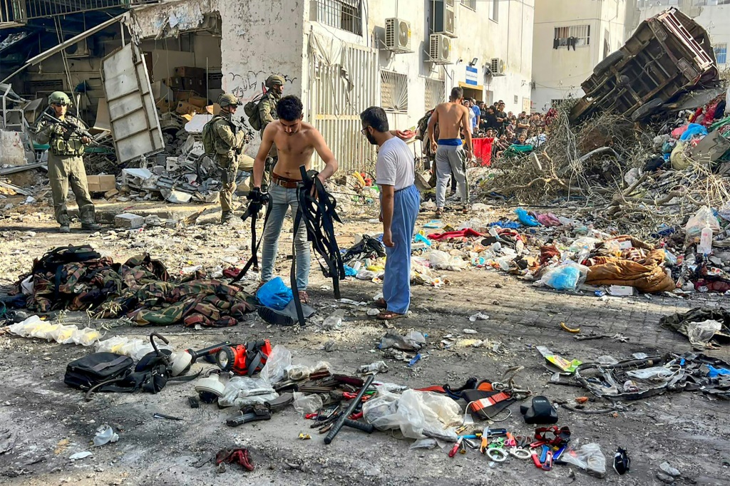 صورة وفرها الجيش الإسرائيلي في 14 كانون الأول ديسمبر 2023 قال إنها تظهر مقاتلين فلسطينيين قرب عتاد عسكري لدى استسلامهم للقوات الإسرائيلية قرب مستشفى كمال عدوان في بيت لاهيا في شمال قطاع غزة (ا ف ب)