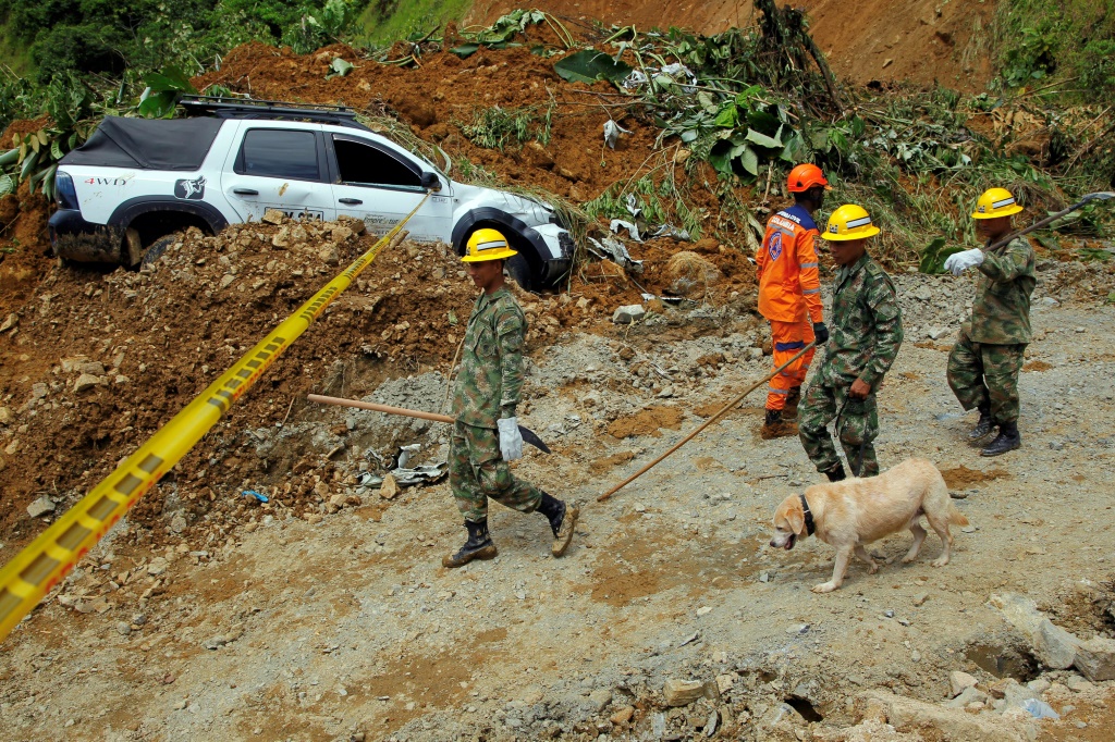 أعضاء فريق الإنقاذ يسيرون بالقرب من الانهيار الأرضي في شمال غرب كولومبيا في 13 يناير 2024 (ا ف ب)