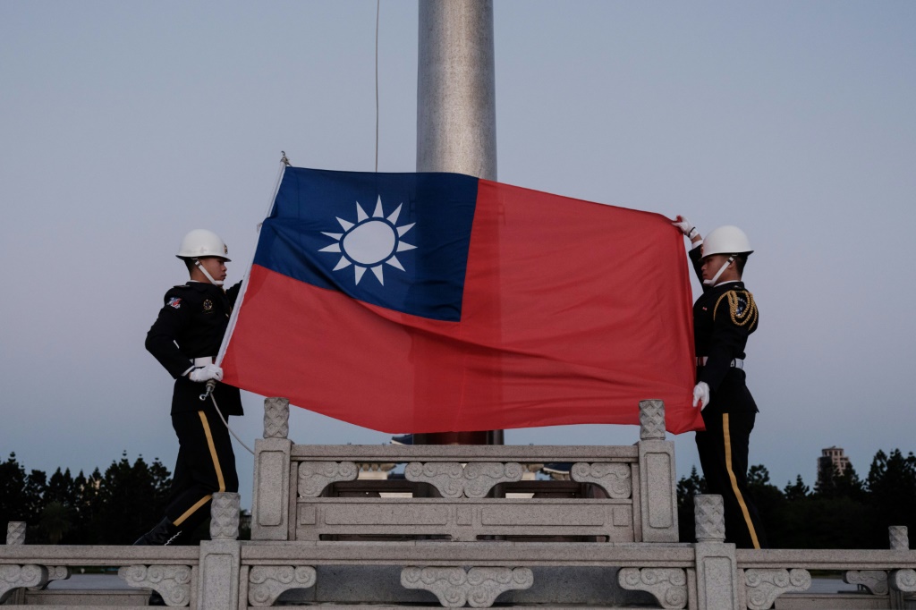 عنصران يرفعان علم تايوان في تايبيه في 14 كانون الثاني/يناير 2024 (أ ف ب)   