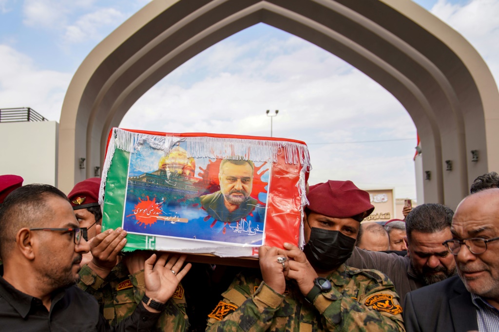 متظاهرون وعناصر من الباسيج يسيرون قرب صاروخ بالستي من الجيل الرابع من طراز خيبر تم عرضه خلال تظاهرة ضد إسرائيل في طهران في 24 ت2/نوفمبر 2023.(ا ف ب)