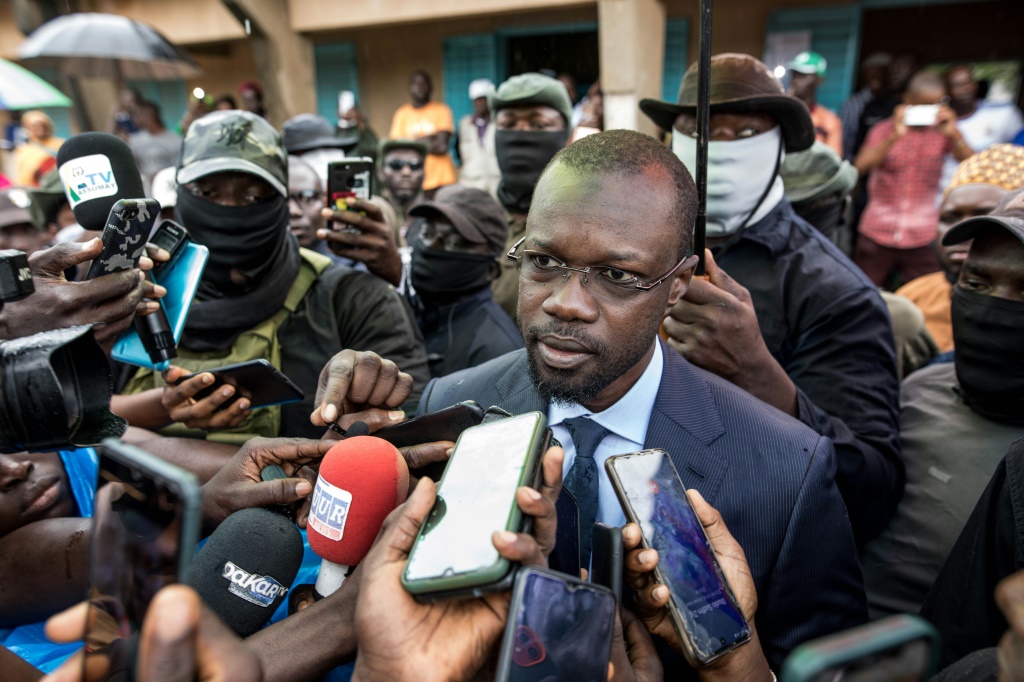 صدر حكم بالسجن على زعيم المعارضة السنغالية عثمان سونكو (وسط) لعدد من التهم التي يقول إنها تهدف إلى منعه من خوض الانتخابات المقررة في 25 فبراير. (ا ف ب)