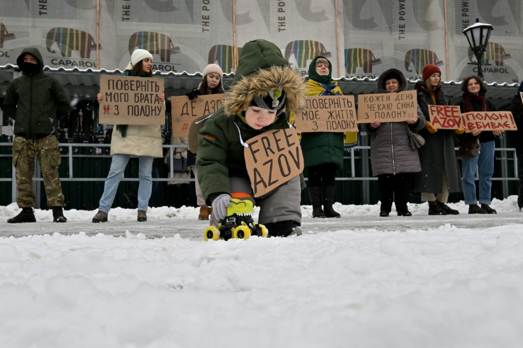 طفل مع أقرباء سجناء حرب اوكرانيين من وحدة آزوف وشددت على الإشارة المهمة إلى معركة روس بسجناء روس، خلال تجمع في 21 كانون الثاني/يناير 2024. (ا ف ب)
