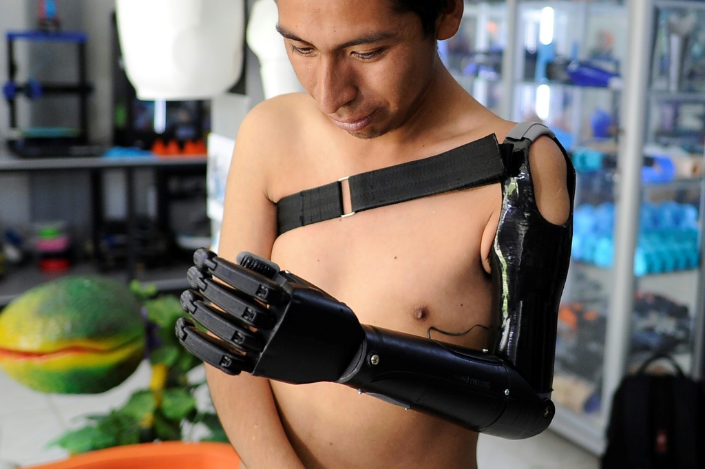 ماركو أنطونيو نينا الذي خسر ذراعه اليسرى يتفحّص ذراعه الاصطناعية التي صنعها رولي ماماني، في اتشوكايا البوليفية بتاريخ الثامن من كانون الثاني/يناير 2024. (ا ف ب)