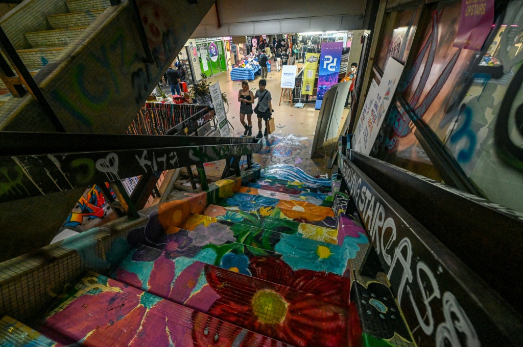 سيطر المبدعون الشباب على مركز تجاري مهجور في سنغافورة، وقاموا برش لوحات جدارية ملونة وعقد ورش عمل فنية. (ا ف ب)