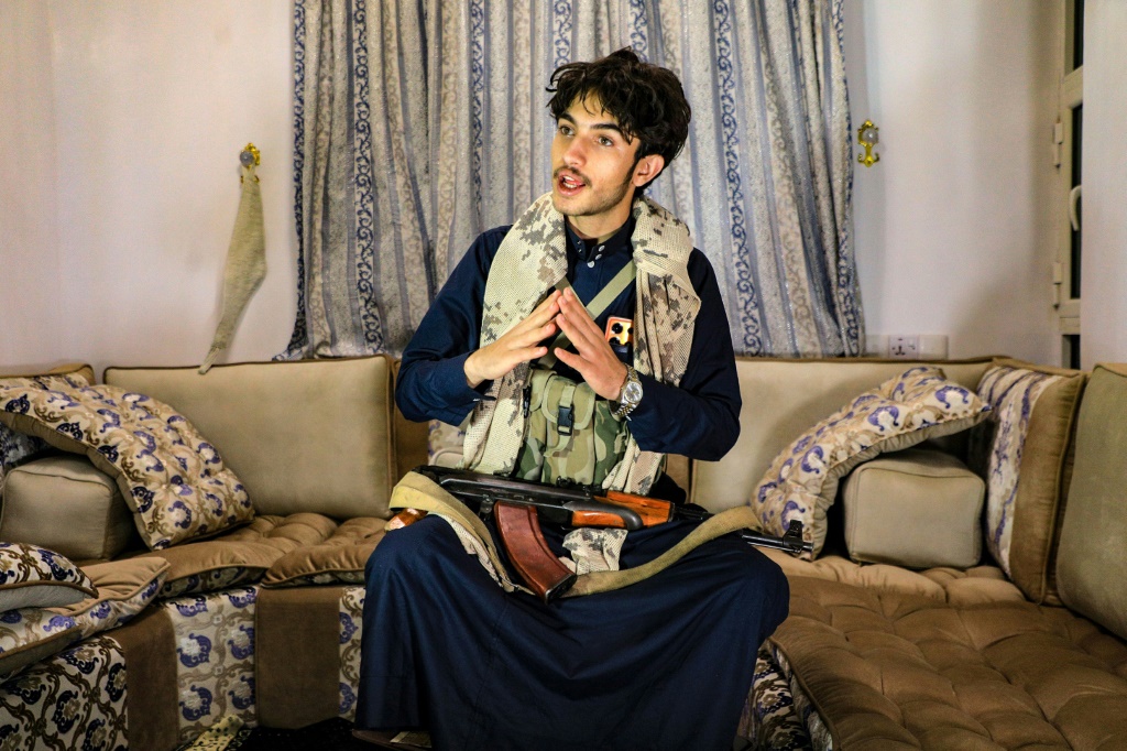 الشاب اليمني راشد الحداد الكبيرا مع صديقه عبر الهاتف، في منزله في صنعاء في 18 ثاني/يناير 2024 (أ ف ب)