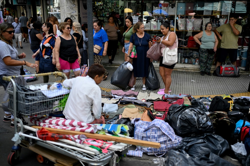 أشخاص يتسوقون في شارع في بوينوس ايرس بتاريخ 5 كانون الثاني/يناير 2024 (أ ف ب)   