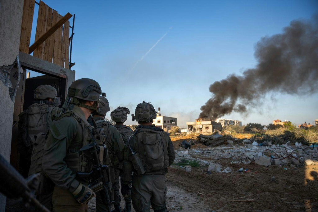 جنود إسرائيليون يراقبون تصاعد الدخان من أحد المباني في غزة (ا ف ب)