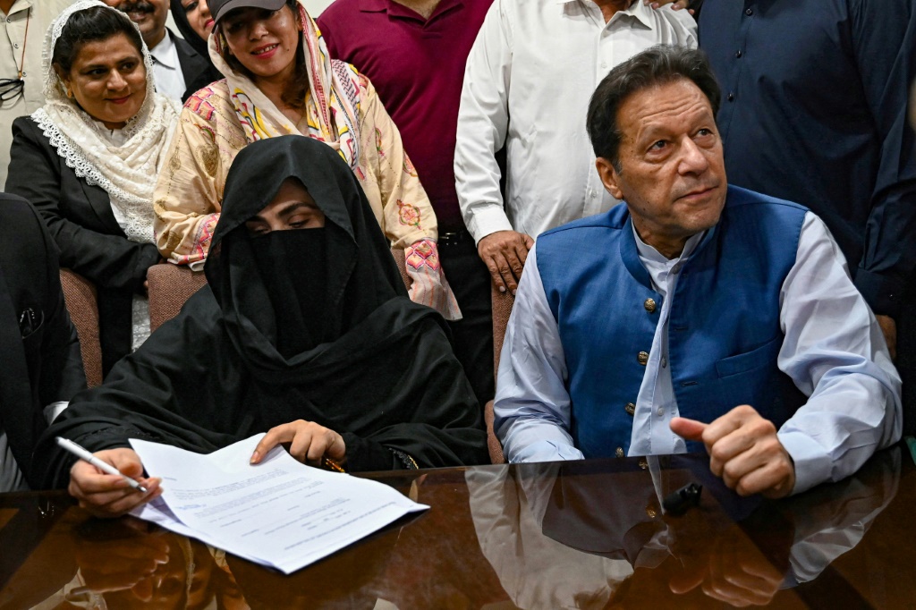 رئيس الوزراء الباكستاني السابق عمران خان (على اليمين) مع زوجته بشرى بيبي (على اليسار) في المحكمة في عام 2023. (ا ف ب)