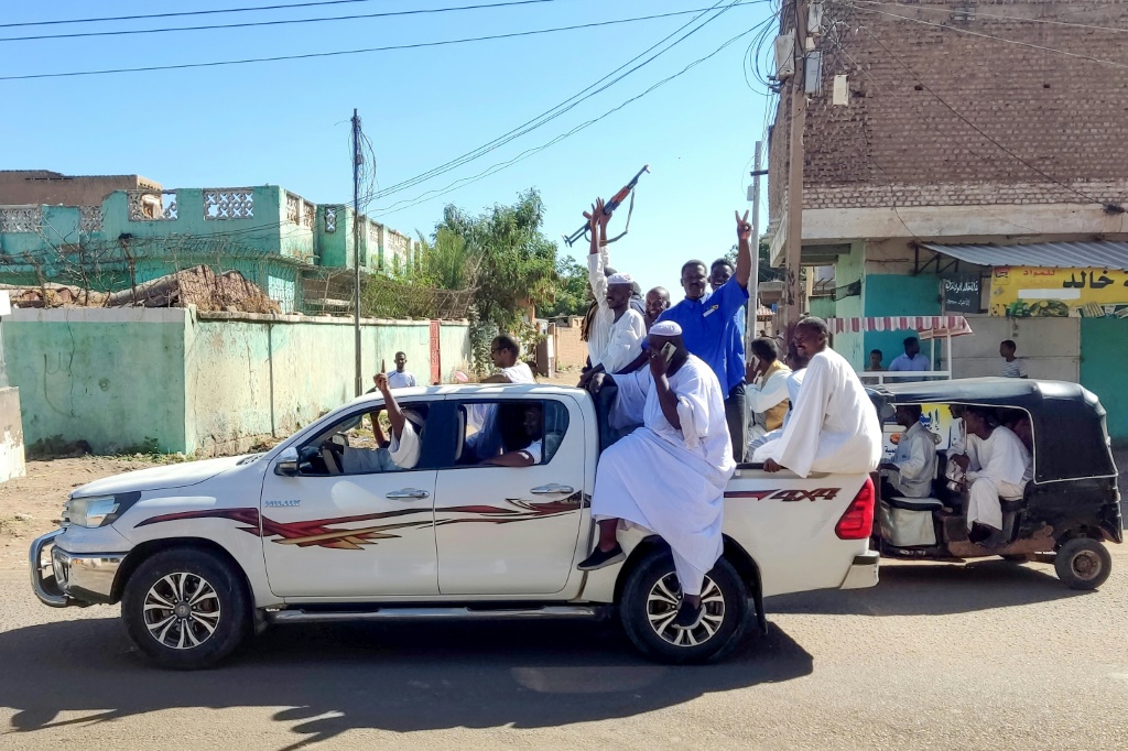 مدنيون سودانيون مسلحون يلوحون بالأسلحة ويرددون شعارات في مدينة القضارف بشرق السودان في 1 يناير 2024 للتعبير عن دعمهم للجيش. (ا ف ب)