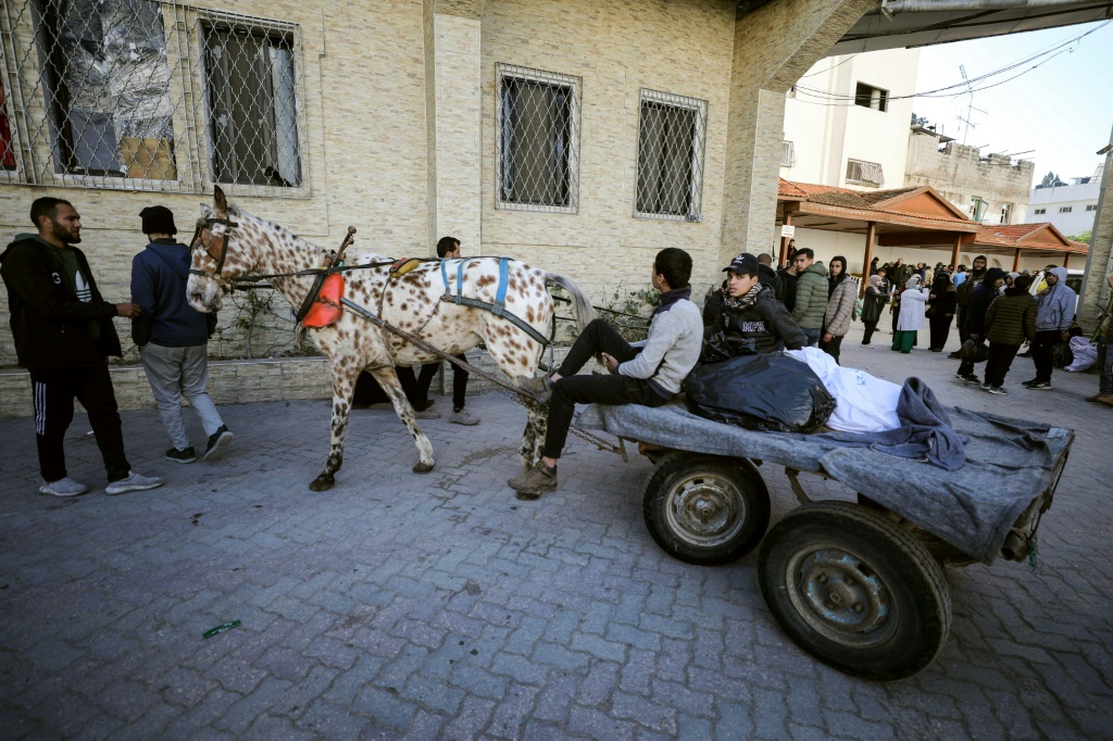 فلسطينيون ينقلون جثثا في عربة يجرها حمار قرب مستشفى الأهلي العربي في قطاع غزة في 31 كانون الثاني/يناير 2024 (أ ف ب)  &nbsp;