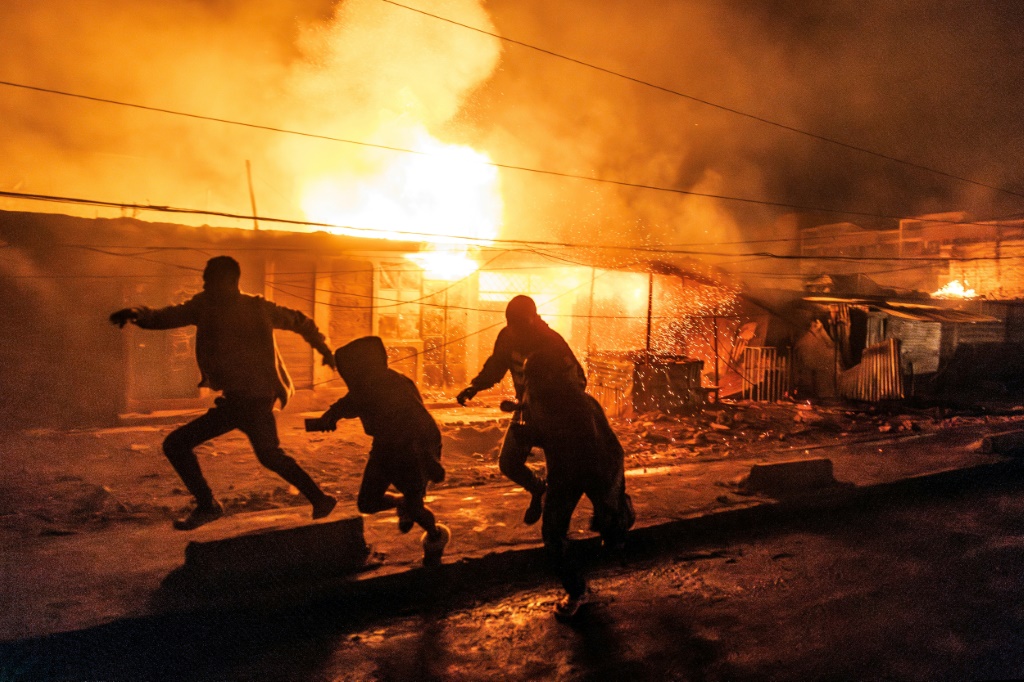سكان يهربون للاحتماء من حريق اندلع إثر انفجار غاز في منطقة إمباكاسي في العاصمة الكينية نيروبي في 2 شباط/فبراير 2024 (ا ف ب)
