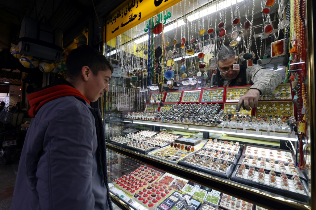 رجل يتأمّل مجموعة من الخواتم ذات الأحجار الكريمة في أحد المتاجر في سوق بجنوب طهران في 8 كانون الثاني/يناير 2024 (ا ف ب)