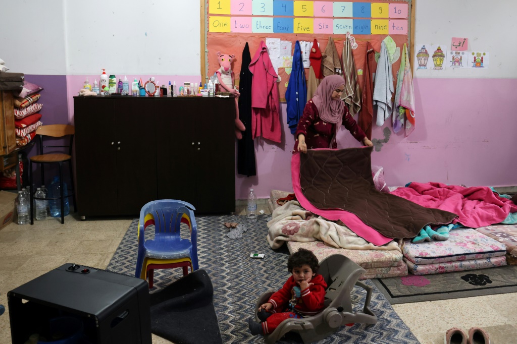    اللبنانية إيناس طحيني التي فرت مع عائلتها من بلدة في جنوب لبنان، توضب الغرفة التي تقيم فيها بمدرسة في مدينة صور في 31 كانون الثاني/يناير 2024 (أ ف ب)   
