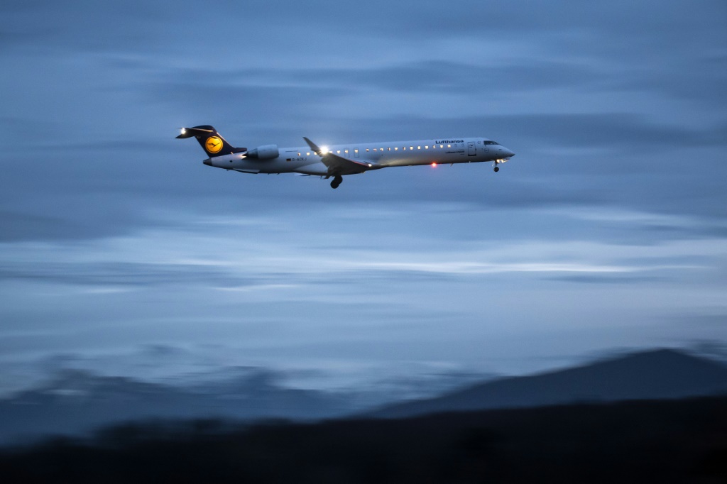 صورة تمّ التقاطها في 23 كانون الثاني/يناير 2024 تظهر طائرة تابعة لشركة Lufthansa CityLine وهي تهبط في مطار جنيف بعد غروب الشمس (أ ف ب)   
