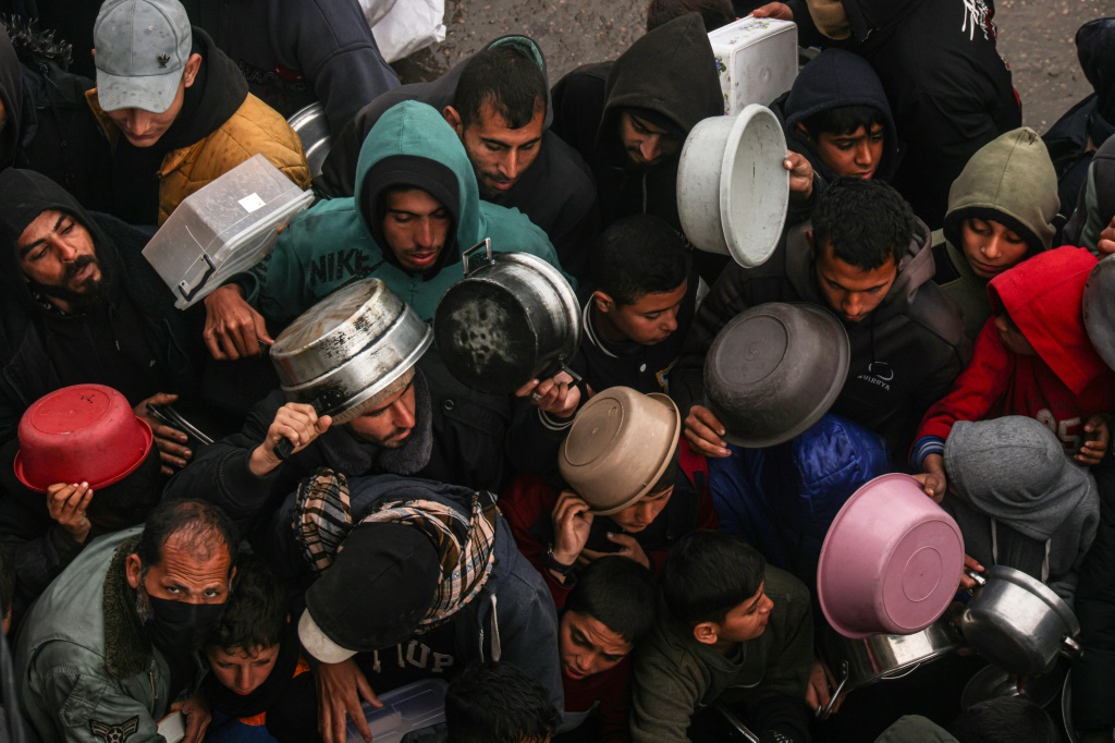 فلسطينيون يحصلون على حصص غذائية في نقطة تبرع في مخيم للنازحين في رفح (ا ف ب)