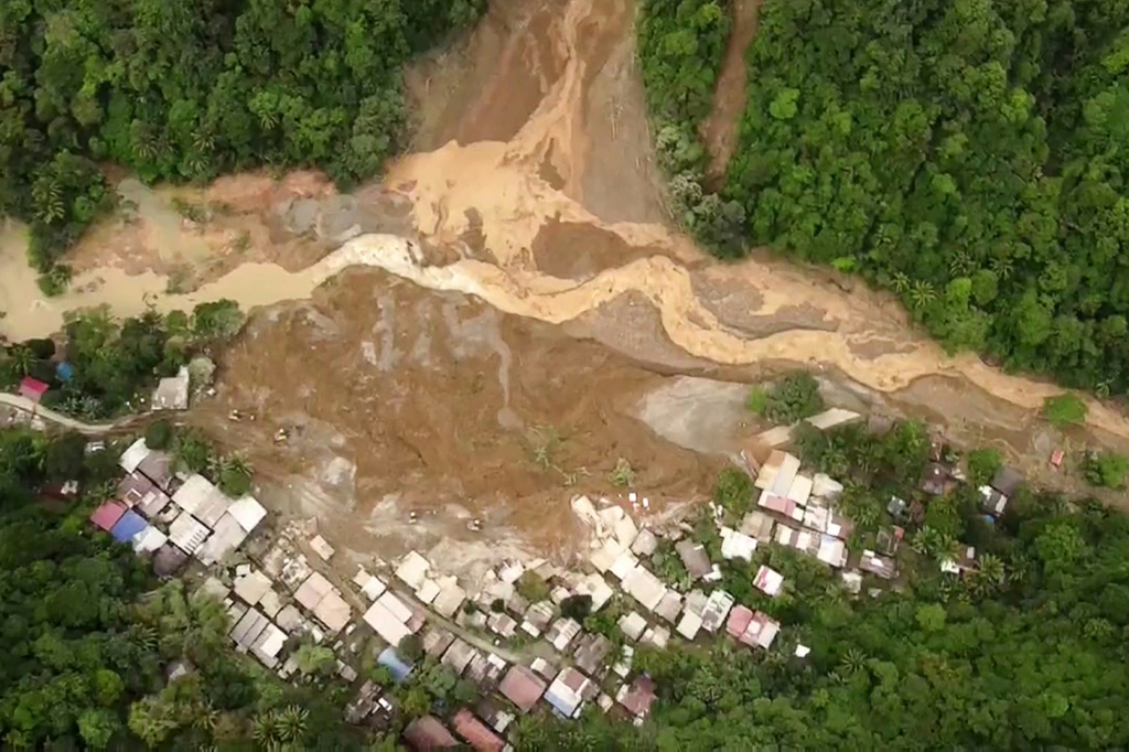 استخدم رجال الإنقاذ أيديهم العارية والمجارف للحفر في الطين في بحث يائس عن ناجين من انهيار أرضي في الفلبين (ا ف ب)