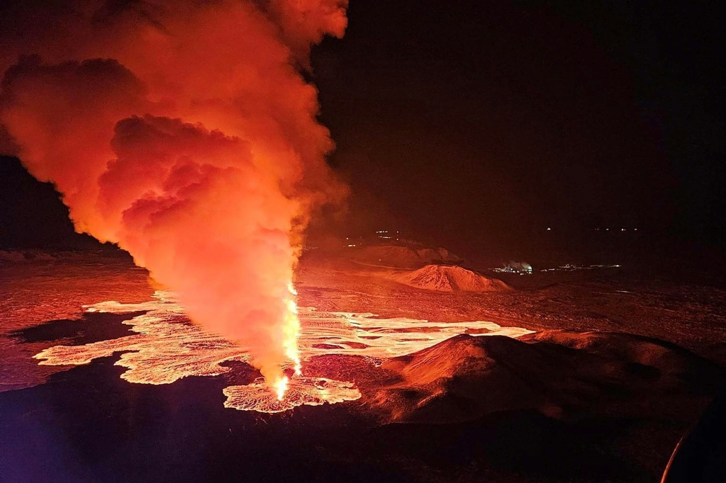 وأظهرت صور فيديو الحمم البركانية تتدفق من الشق وتضيء عمودًا من الدخان (أ ف ب)   