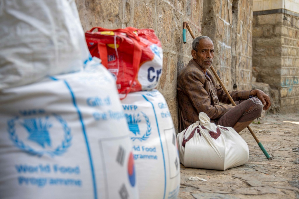 نازحون مدنيون في مدينة تعز اليمنية يتلقون مساعدات إنسانية مقدمة من برنامج الغذاء العالمي (أ ف ب)   