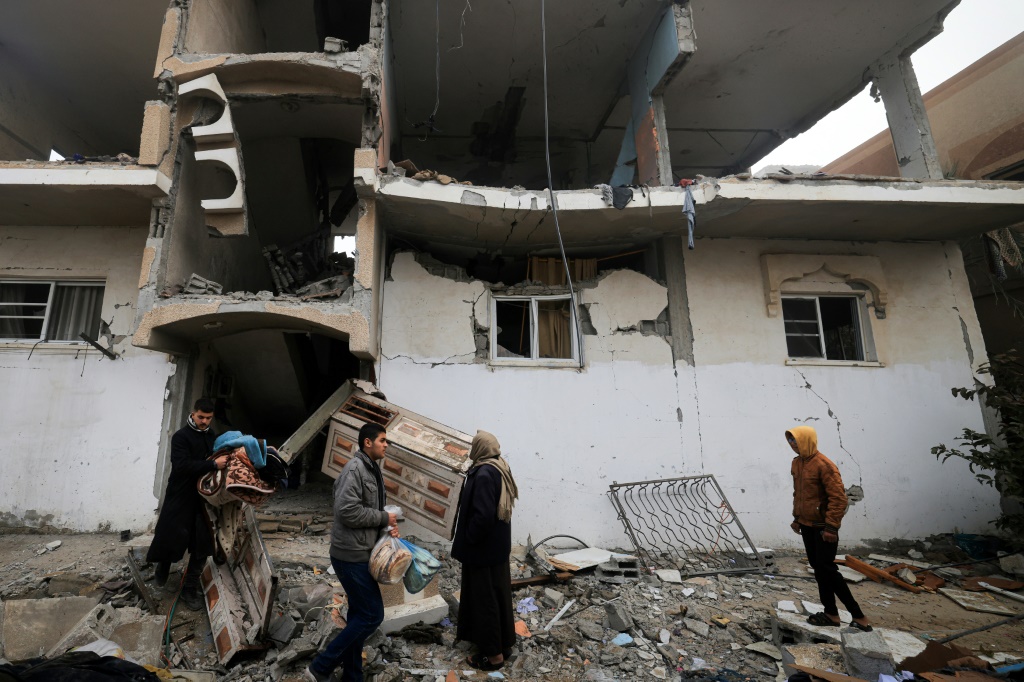 فلسطينيون يجمعون حاجياتهم من مبنى متضرر من القصف الإسرائيلي في مدينة رفح في التاسع من شباط/فبراير 2024 (ا ف ب)