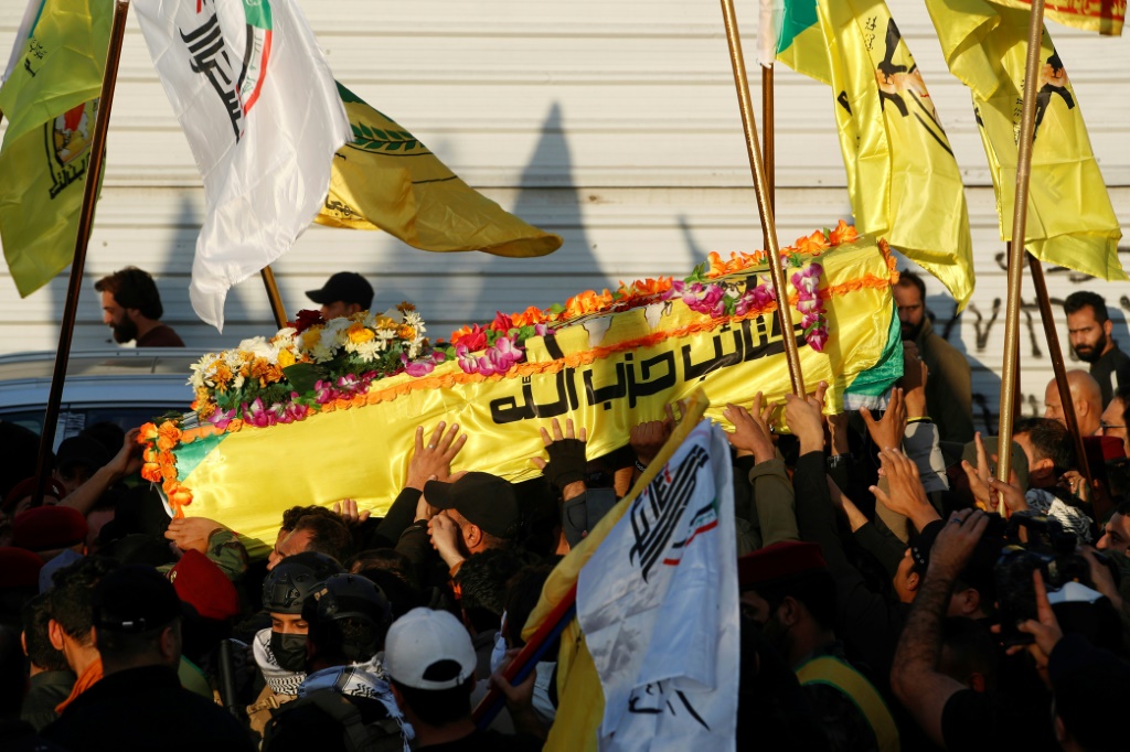 عناصر من الحشد الشعبي يرفعون نعش القيادي في كتائب حزب الله أبو باقر الساعدي خلال تشييعه في بغداد في 8 شباط/فبراير 2024 (أ ف ب)   