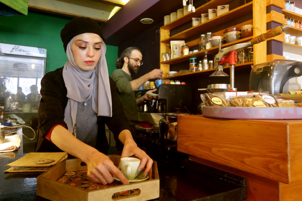 صاحب المقهى إحسان العظمة (يمين) يعد القهوة في دمشق بتاريخ 30 كانون الثاني/يناير 2023 (أ ف ب)   