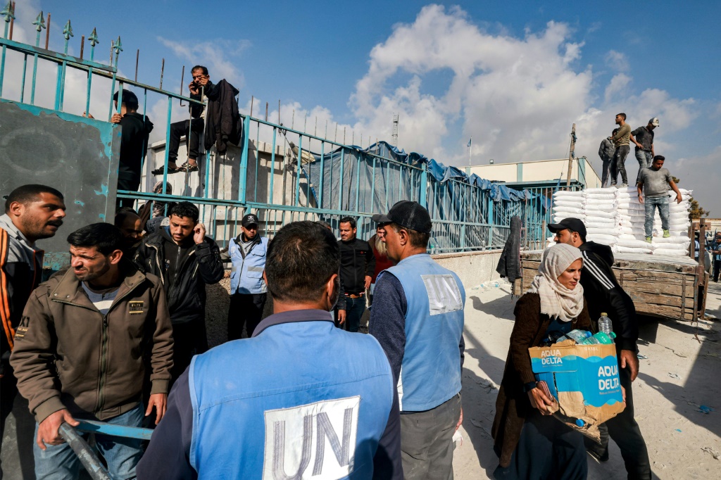 عاملون في وكالة غوث وتشغيل اللاجئين الفلسطينيين (اونروا) يوزعون مساعدات على السكان في رفح جنوب قطاع غزة في 12 كانون الاول/ديسمبر 2023 (ا ف ب)   